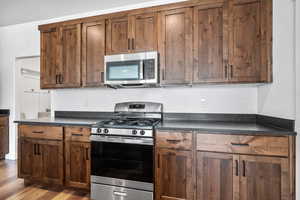 Kitchen with light wood-type flooring and appliances with stainless steel finishes