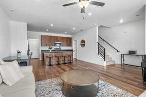 Living room featuring ceiling fan, sink, and dark hardwood / wood-style flooring