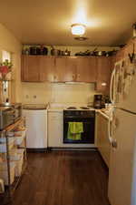 Kitchen featuring white fridge, dark hardwood / wood-style floors, electric range, and fridge