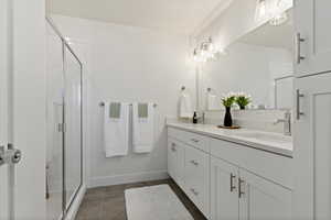 Bathroom with tile patterned flooring, vanity, and an enclosed shower