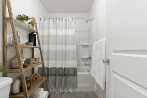 Bathroom featuring tile patterned flooring, toilet, and shower / bath combo with shower curtain