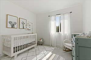 Bedroom featuring a nursery area and light carpet