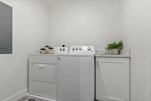 Laundry area with sink, washer and clothes dryer, electric panel, cabinets, and tile patterned floors