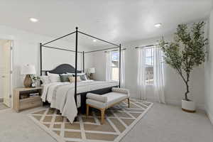 Bedroom with light colored carpet and a textured ceiling