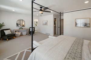 Carpeted bedroom with a walk in closet, a closet, ceiling fan, and ensuite bathroom