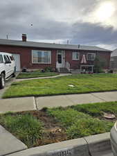 View of front facade featuring a garage and a front lawn