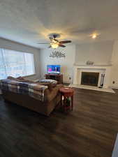 Living room with dark wood-type flooring and ceiling fan