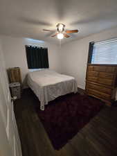 Bedroom featuring dark wood-type flooring and ceiling fan