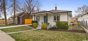 Bungalow featuring covered porch and a front lawn