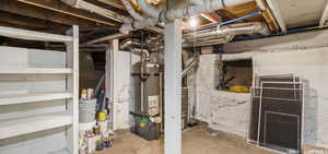 Basement featuring secured water heater, utility room and storage capacity