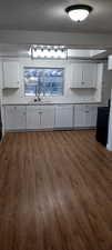 Kitchen with white cabinetry, sink, a textured ceiling, and white dishwasher