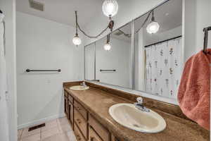 Bathroom featuring vanity, curtained shower, and tile patterned floors