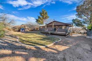 Exterior space featuring a storage shed, a deck, and a front lawn