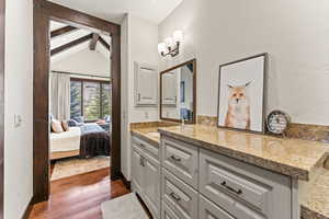 Bathroom featuring vanity, hardwood / wood-style flooring, and lofted ceiling with beams