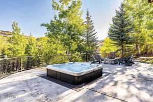 View of patio with an outdoor fire pit and an outdoor hot tub