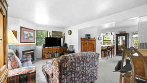 Living room with plenty of natural light, a tile fireplace, and light carpet