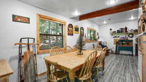 Dining room with beamed ceiling and wood-type flooring