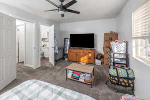 Bedroom featuring ensuite bath, carpet floors, and ceiling fan