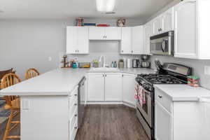 Kitchen featuring stainless steel appliances, a breakfast bar, sink, and kitchen peninsula