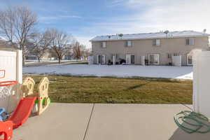 Back of house with a patio and a lawn