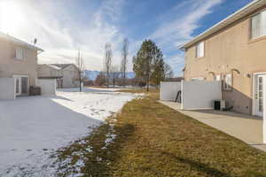 Snowy yard with a patio and cooling unit