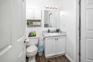 Bathroom with vanity, wood-type flooring, and toilet