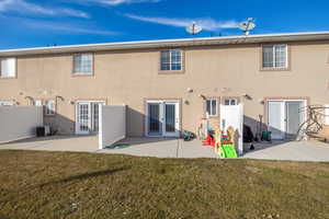 Rear view of house featuring cooling unit, a patio, a yard, and french doors