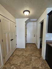 Hall featuring a textured ceiling