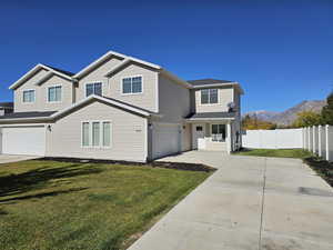 View of front of house featuring a garage, a mountain view, and a front yard