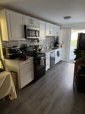 Kitchen featuring white cabinetry, sink, dark hardwood / wood-style floors, and appliances with stainless steel finishes