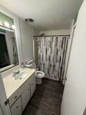 Bathroom with vanity, toilet, and hardwood / wood-style floors