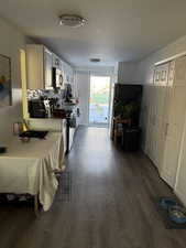 Interior space with dark hardwood / wood-style flooring, sink, decorative backsplash, and white cabinets