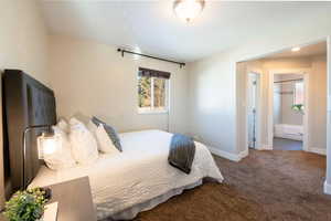 Carpeted bedroom featuring ensuite bath