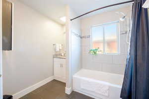 Bathroom with shower / tub combo with curtain, vanity, and tile patterned flooring