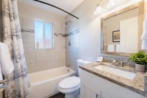 Full bathroom featuring vanity, toilet, and shower / bath combo with shower curtain