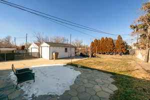 View of yard with an outbuilding, a garage, and a patio