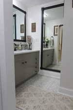 Bathroom featuring vanity and decorative backsplash