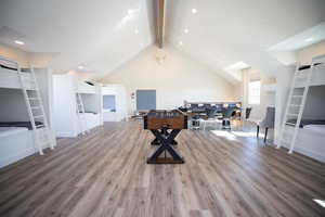 Interior space with beamed ceiling, high vaulted ceiling, and hardwood / wood-style flooring