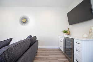 Office featuring bar area, beverage cooler, and light hardwood / wood-style flooring