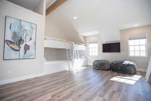 Living area with high vaulted ceiling, beamed ceiling, and light wood-type flooring