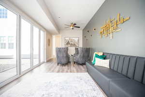 Living room with ceiling fan and light hardwood / wood-style flooring