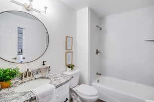 Full bathroom with vanity, shower / washtub combination, and toilet