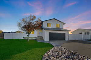 View of front of house featuring a garage and a lawn