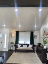 Living room with wood-type flooring and vaulted ceiling