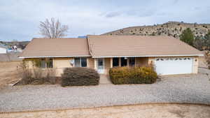 Ranch-style house with a garage and a mountain view