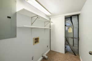 Washroom with washer hookup, electric panel, hookup for an electric dryer, and a textured ceiling