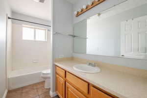 Full bathroom featuring vanity, bathing tub / shower combination, tile patterned floors, and toilet