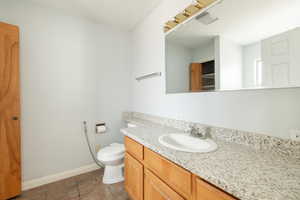 Bathroom featuring vanity, tile patterned floors, and toilet