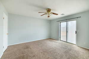 Carpeted empty room featuring ceiling fan