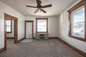 Unfurnished room featuring light colored carpet and ceiling fan